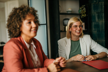 Businesswomen working in the office. Sitting and talking. Focus on young blond woman