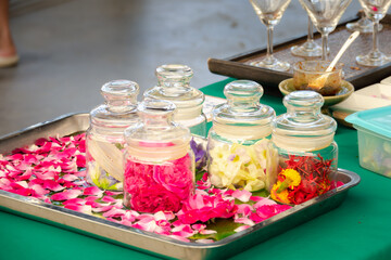 A tray with several glass jars filled with flowers and a green tablecloth