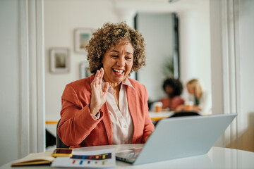 Obraz premium Successful businesswoman using a laptop and having a video call, working in the office
