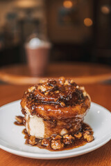 Caramel bun bakery dessert served on wooden table in the cafe.