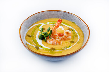 Pumpkin soup with shrimp on a white background.