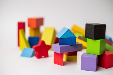 wooden blocks of different colors randomly placed against white background with selective focus on some blocks, business concept