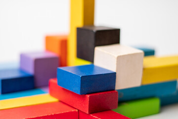 Colorful wooden blocks geometrically arranged forming different shapes, structures, architecture and buildings, isolated on white background