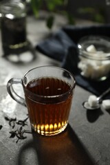 Tasty hot tea in cup on grey table, closeup