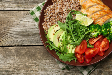 Healthy meal. Tasty products in bowl on wooden table, top view. Space for text