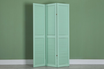 One folding screen near green wall indoors