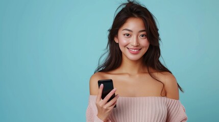 Naklejka premium Portrait of attractive Asian girl using phone, app smm post isolated on bright blue color background