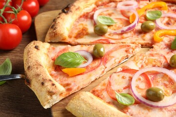 Cut delicious vegetarian pizza on wooden table, closeup