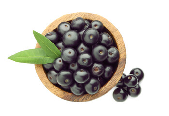 Fresh ripe acai berries in bowl and green leaves isolated on white, top view