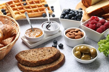Tasty breakfast. Many different food on grey textured table, closeup