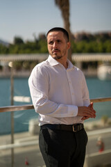 Hombre joven con traje y camisa en sitio lujoso con mar.  Business man. Trabajando con tablet y...