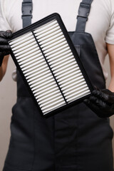 New air filter in hands of car mechanic, close-up. Concept for auto parts replacement, maintenance, car repair, auto parts sales. Vertical