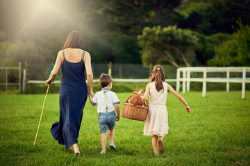 Picnic, back of family and walking in garden for play, bonding and adventure with teddy bear. Mom, children and together on ranch for love, outdoor activity and net for catching butterflies at home