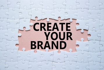 Create your Brand symbol. Concept words Create your Brand on white puzzle. Beautiful pink background. Business and Create your Brand concept. Copy space.