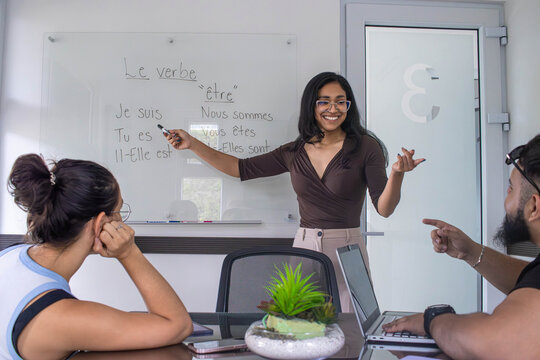 Latin American teacher teaching French to students.