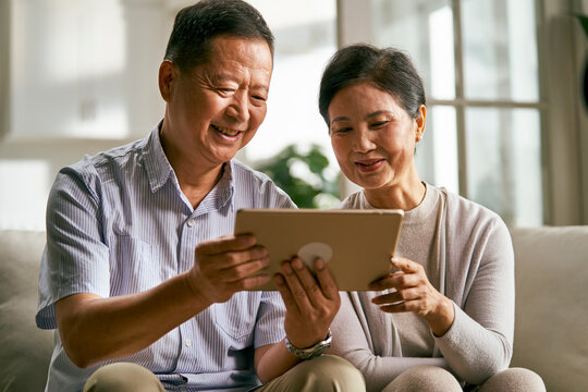 senior asian couple using digital tablet together at home