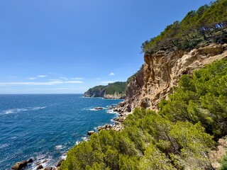 rocky coastline with cliff at the Costa Brava at the Mediterranean Sea between Sa Tuna and Fornells seen from the hiking trail Camí de Ronda near Begur, Catalonia, Costa Brava, Girona, Spain