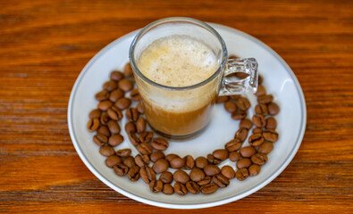 Espresso coffee served in a transparent cup with roasted coffee beans. Gourmet, 100% Arabica special