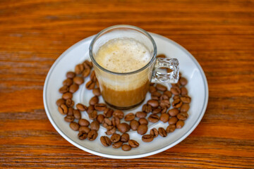 Espresso coffee served in a transparent cup with roasted coffee beans. Gourmet, 100% Arabica special