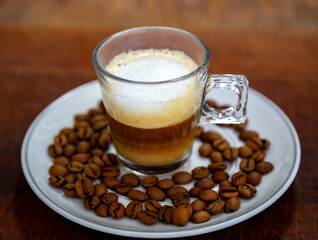 Espresso coffee served in a transparent cup with roasted coffee beans. Gourmet, 100% Arabica special