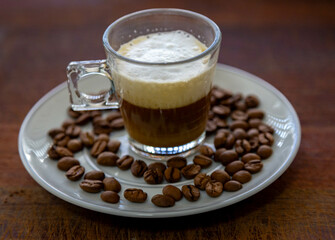 Espresso coffee served in a transparent cup with roasted coffee beans. Gourmet, 100% Arabica special