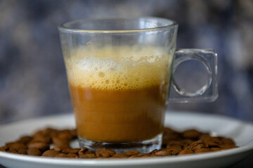 Espresso coffee served in a transparent cup with roasted coffee beans. Gourmet, 100% Arabica special