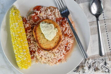 salmon top with tarter sauce  with rice and corn