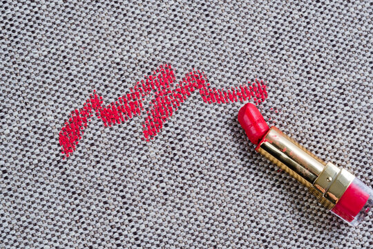 Dirty red lipstick stains on gray background carpet and on upholstery. Cleaning of makeup stains. life stain concept. top view.