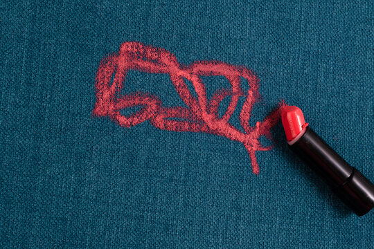 Broken lipstick. Dirty pink lipstick stains on a blue background carpet and on upholstery. Cleaning of makeup stains. life stain concept. top view