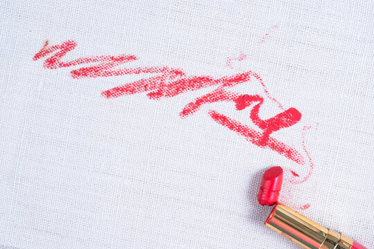 Dirty red lipstick stains on white background carpet and on upholstery. Cleaning of makeup stains. life stain concept. top view