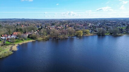Obraz premium Drone view of a small lake in low sun surrounded by fields and woods.