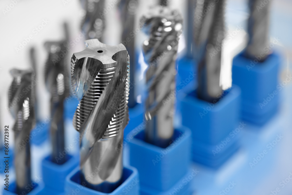 Poster A row of metal tools with blue plastic holders. The tools are all different sizes and shapes. Concept of organization and precision, as the tools are neatly arranged in their respective holders