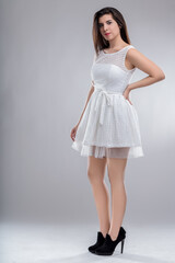Young latin woman posing wearing white dress and high heels