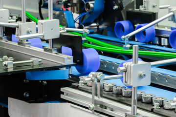 Part of a modern roller conveyor with metal and plastic rollers for the production of various products, industrial concept background.