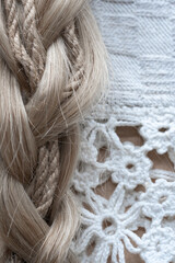 Blonde hair intertwined with jute rope, creating a unique texture contrast. This visually intriguing image is suitable for themes of natural materials, beauty, and artisanal crafts.
