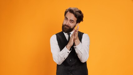 Friendly waiter clapping hands in admiration as they applaud somebody on camera for their achievements. Enthusiastic server in formal outfit offers someone encouraging morale lift.