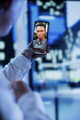 Woman in videocall with boyfriend while strolling around city streets at night, close up. Citizen using smartphone to show partner surroundings in dimly illuminated town center in blurry background