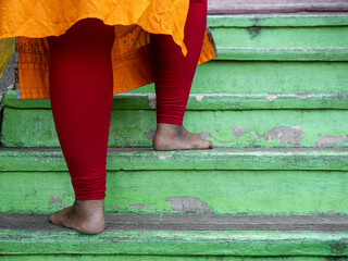 Close-Up of an Hindu Elderly Woman Ascending Worn Green Steps at Batu Caves Barefoot - Spiritual...