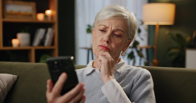 Senior woman, phone and confused on sofa with idea, scroll and search for solution in living room. Person, smartphone and thinking with social media, game and mobile app in on couch at nursing home