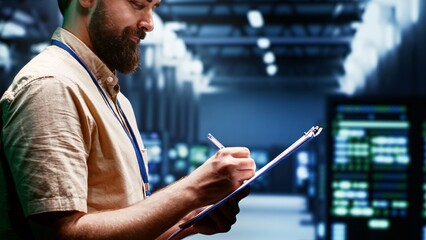 Supervisor monitoring energy efficient servers using renewable sources to minimize consumption and reduce overall facility carbon footprint. Technician working in eco friendly data center