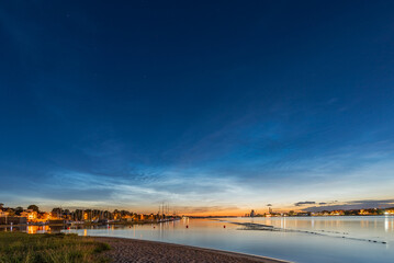 Noctilucent clouds over the Daugava river in Kipsala island, Riga, Latvia on June night.
