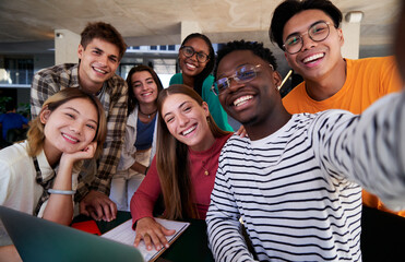 Happy selfie of a multiethnic group of student friends gathered at university studying in the...