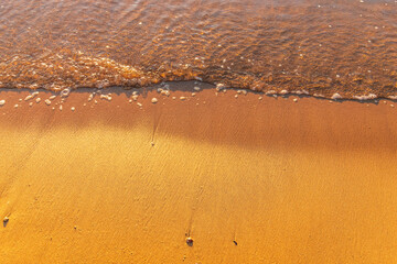 Soft wave of the sea on the sandy beach.