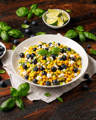 Blueberry Corn Feta Salad in white plate on wooden table. Healthy food
