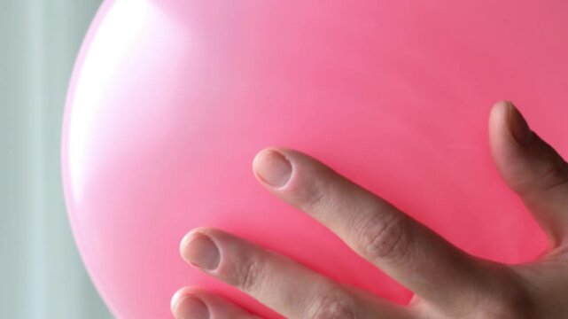 Pink balloon. Girl inflates a pink balloon close-up.Birthday, baby shower or party decoration. Festive paraphernalia and decorations. 4k footage