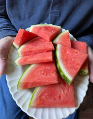 Platter of watermelon slices held by man