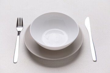 Table setting with clean plates and cutlery on white background