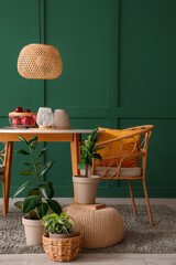 Interior of stylish room with dining table, pouf and plants