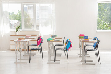 Interior of classroom with desks and backpacks