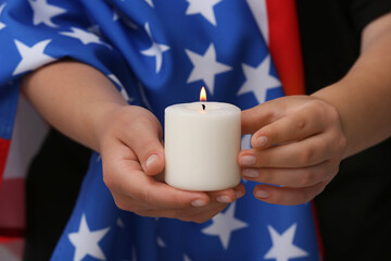 Woman with flag of USA holding burning candle, closeup. National Day of Prayer and Remembrance for...